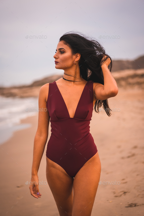 A young brunette Caucasian woman in a maroon swimsuit